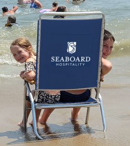 kids peek around corners of seaboard hospitality beach chairs